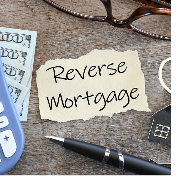 Handwritten note reading Reverse Mortgage on a desk
